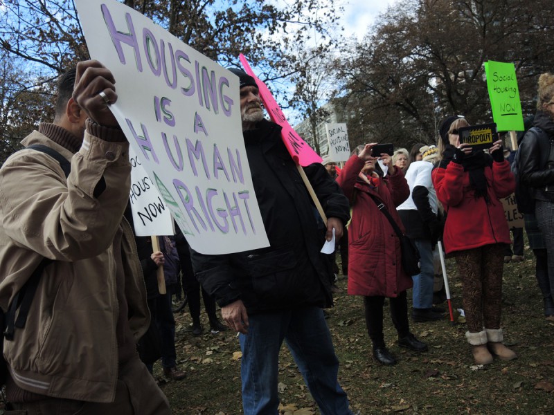 About 200 people gather for a rally at Allan Gardens during Toronto’s National Housing Day of Action to listen to speeches before marching to federal Finance Minister Bill Morneau’s constituency office. A person holds a sign that says