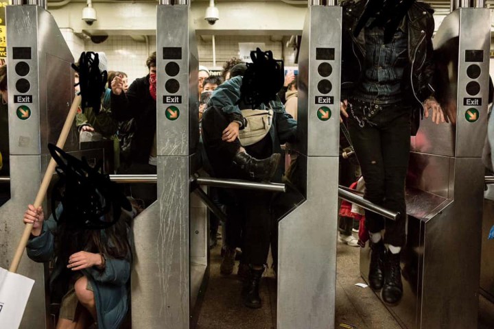 Three people duck under or jump over subway turnstiles. Their faces are blacked out.