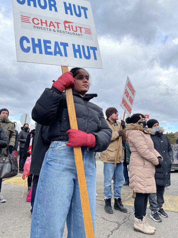 A photo of Satinder holding a sign that says